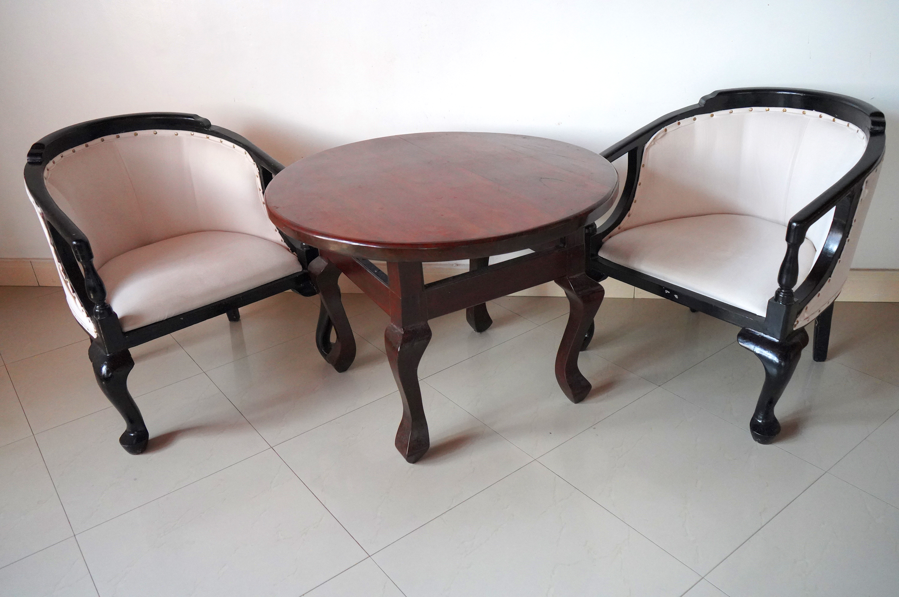Two classic wooden chairs with a round coffee table