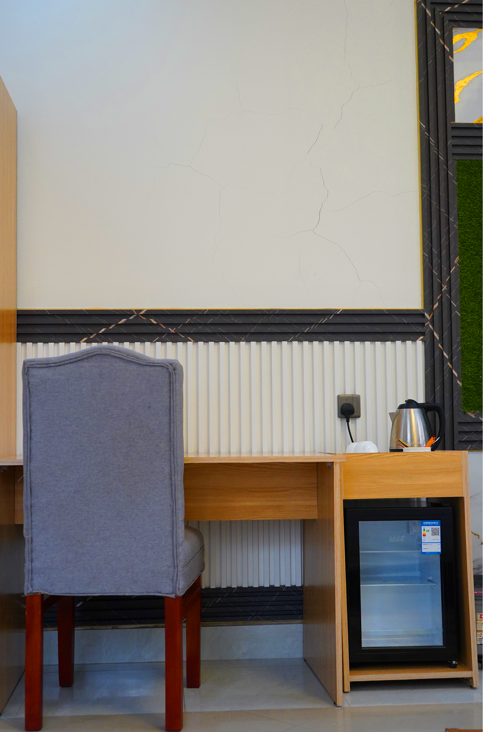Portrait detail of the work desk, chair, kettle and mini fridge