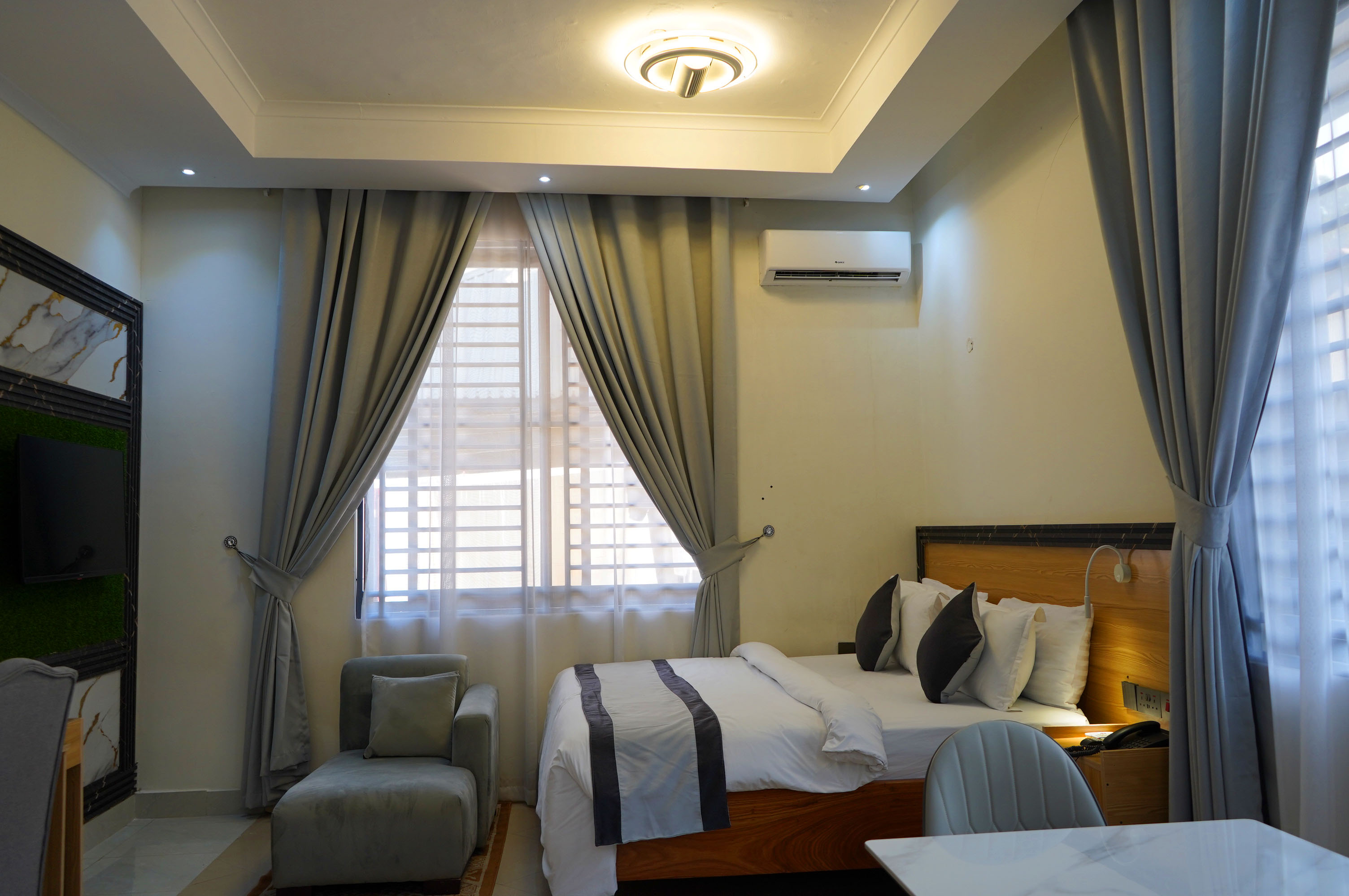 Wide interior view of the bed framed by grey curtains
