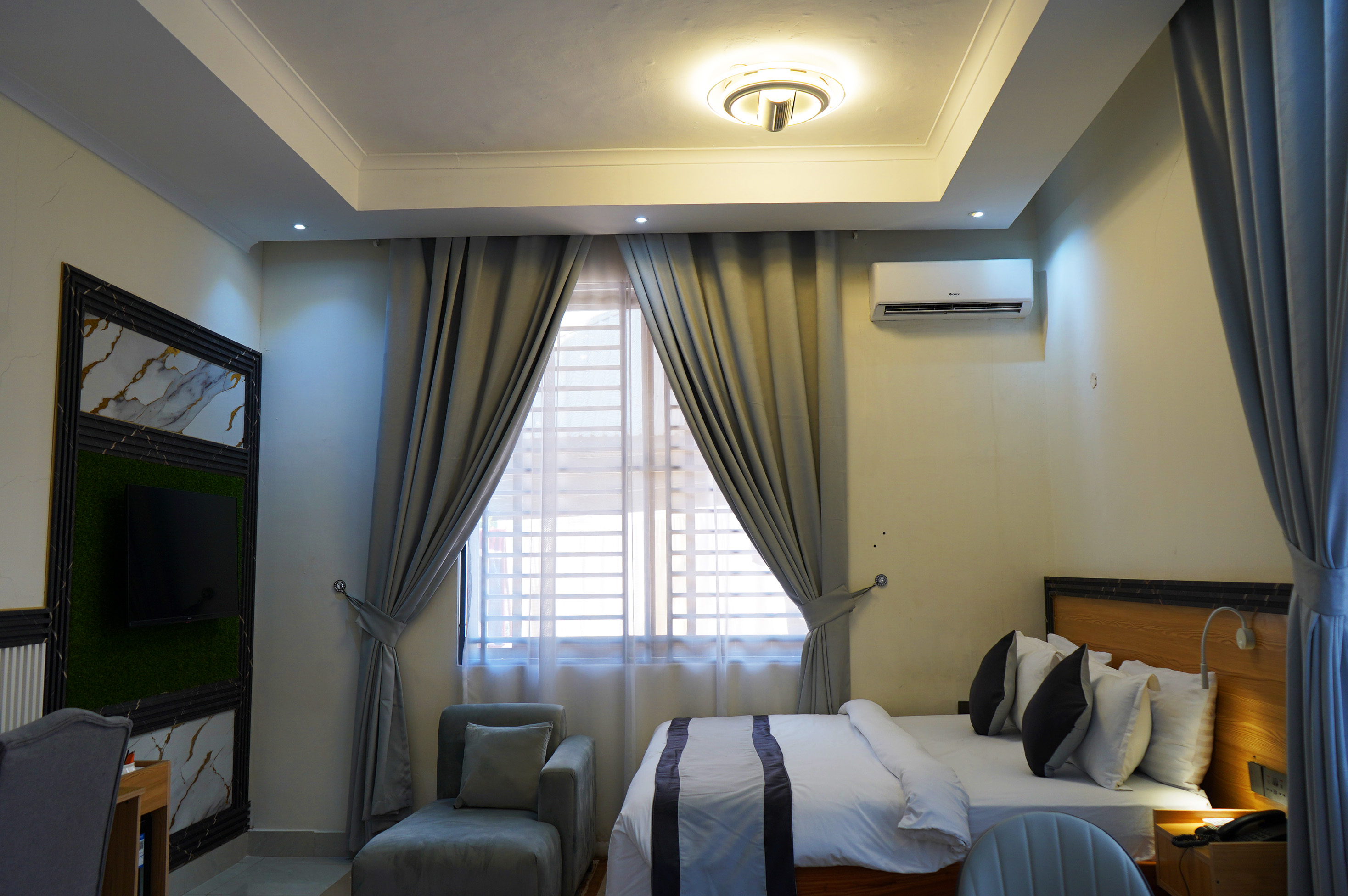 Room view showing the bed opposite a wall-mounted television